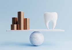 Illustration of tooth balanced against stacks of coins