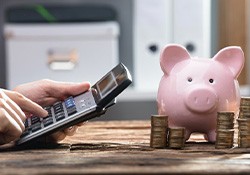 Pocket calculator next to piggy bank