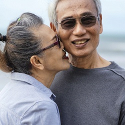 a couple walking on the beach kissing each other