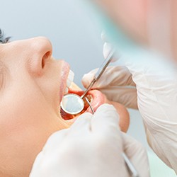 dentist looking in patient’s mouth 