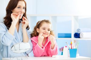 Mother and daughter caring for teeth before visiting their family dentist