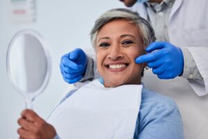 Woman smiling after getting a cosmetic dental treatment